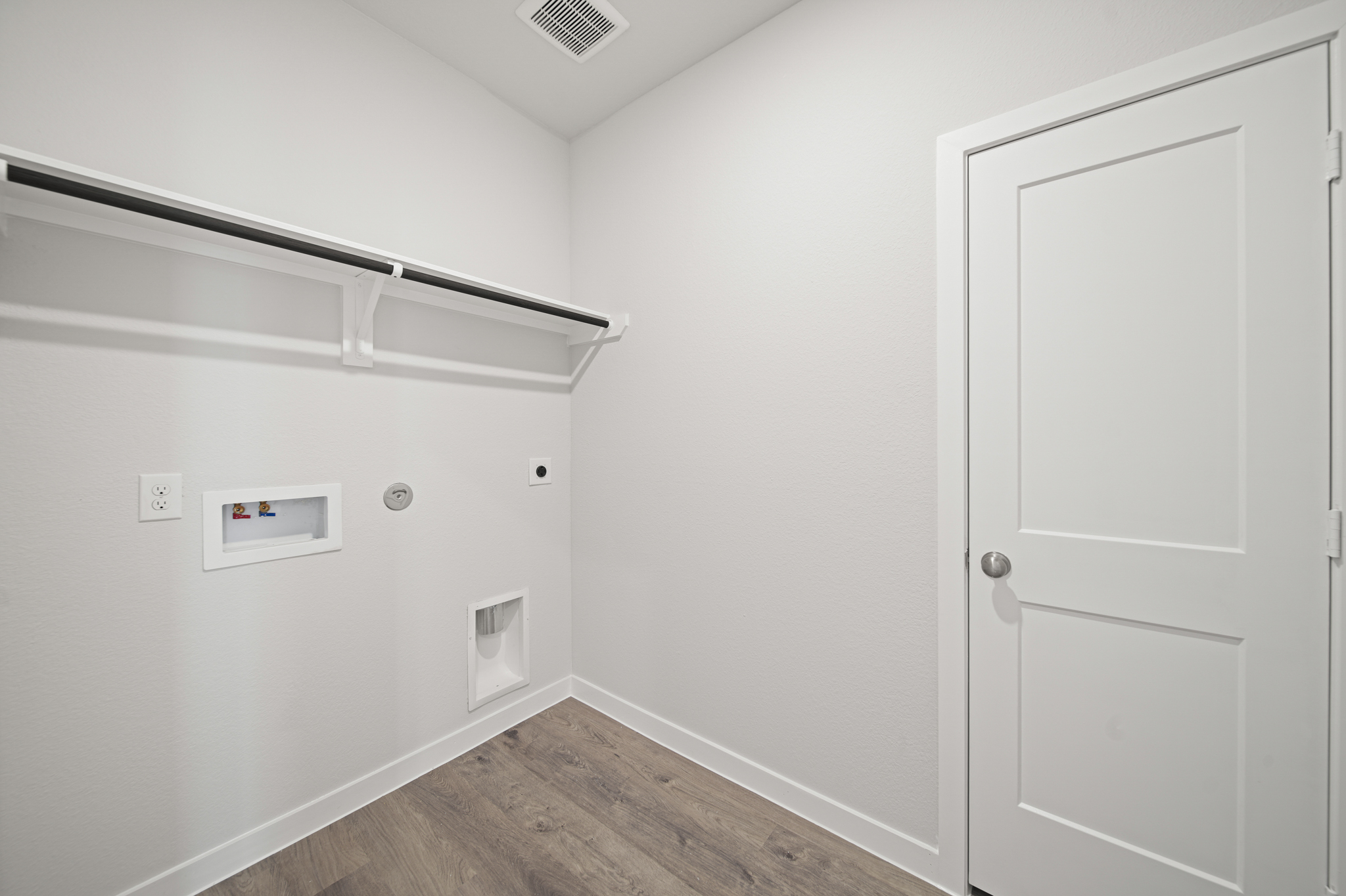 A white room with a wood floor and white walls.