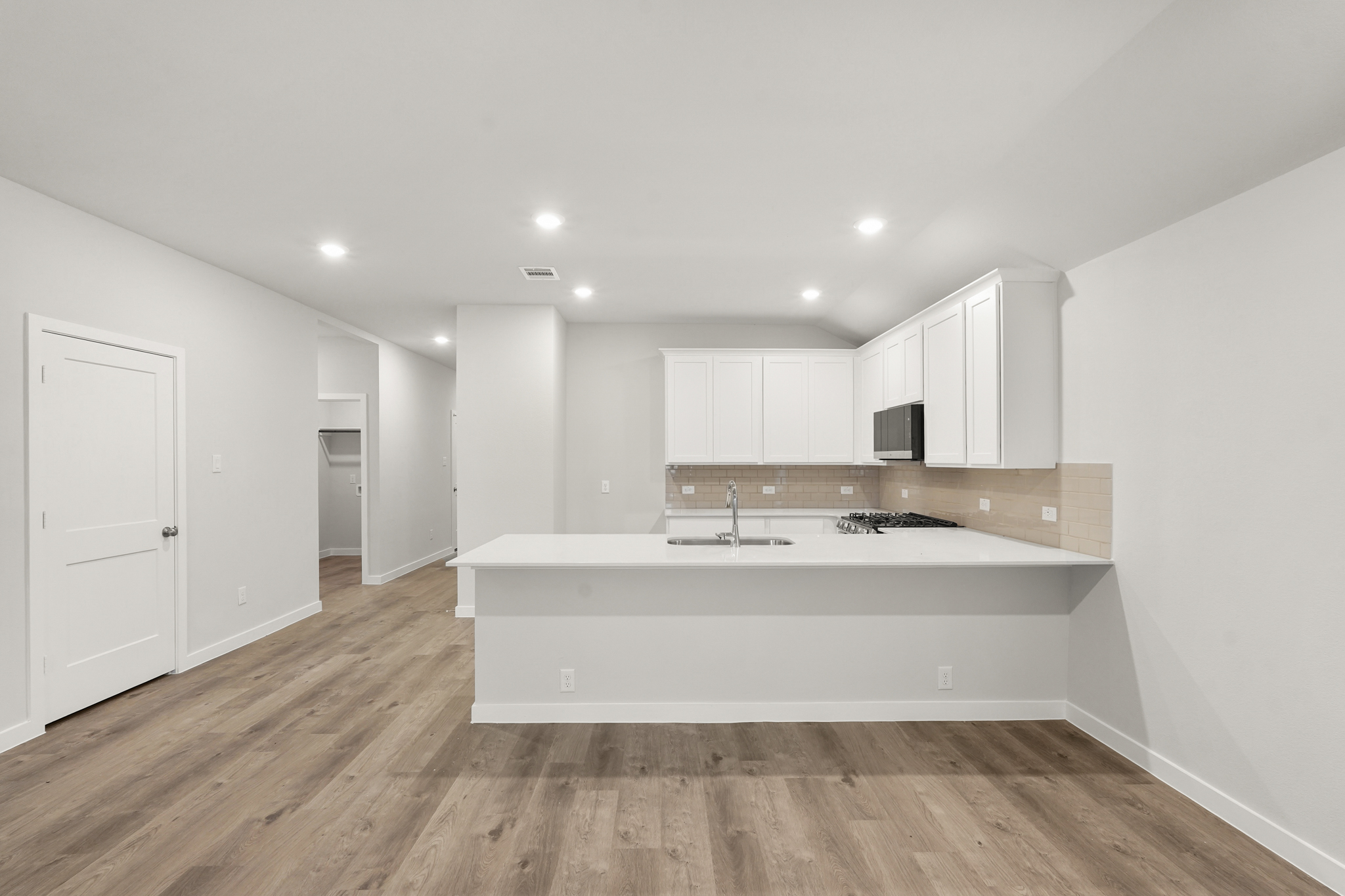 A kitchen with white cabinets.