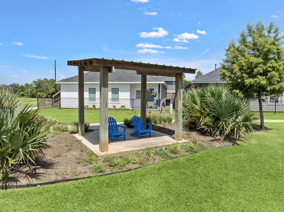 A gazebo with chairs and a pool in a yard.