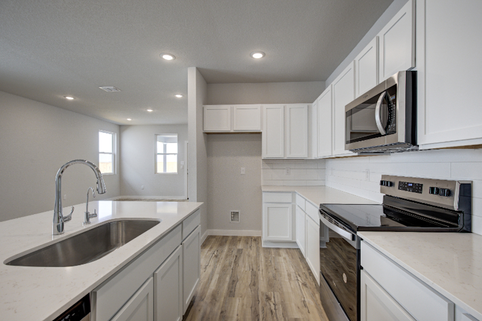 A kitchen with white cabinets.