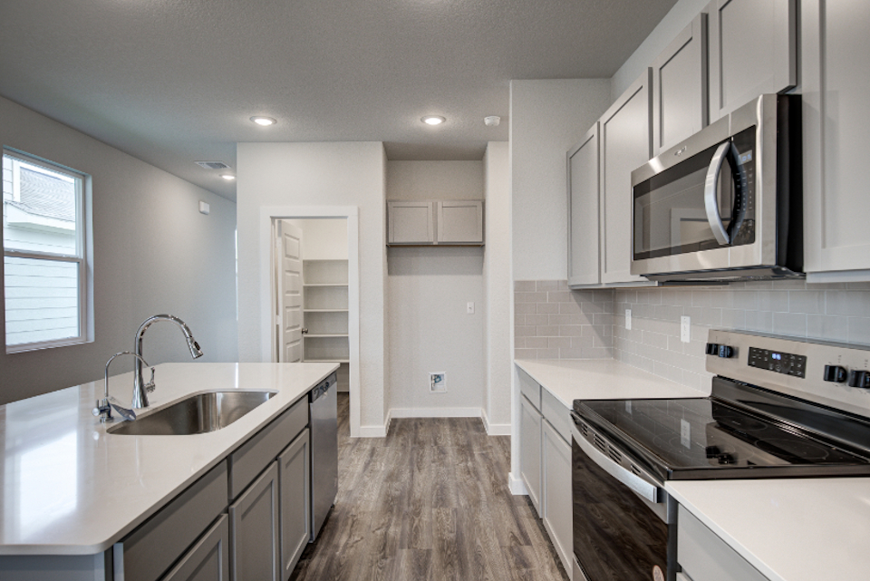 A kitchen with white cabinets.