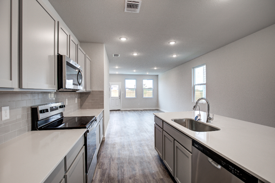 A kitchen with white cabinets.