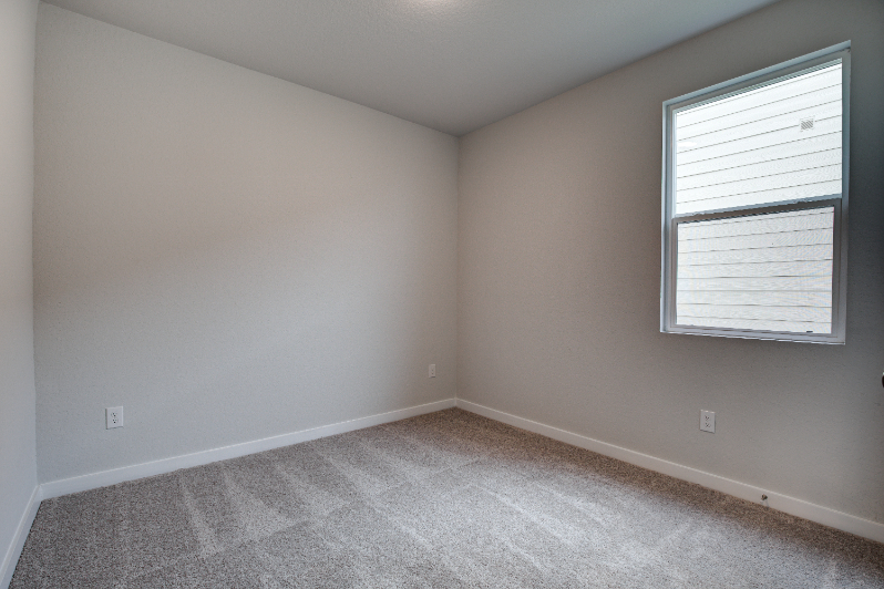 A room with a window and a carpet.