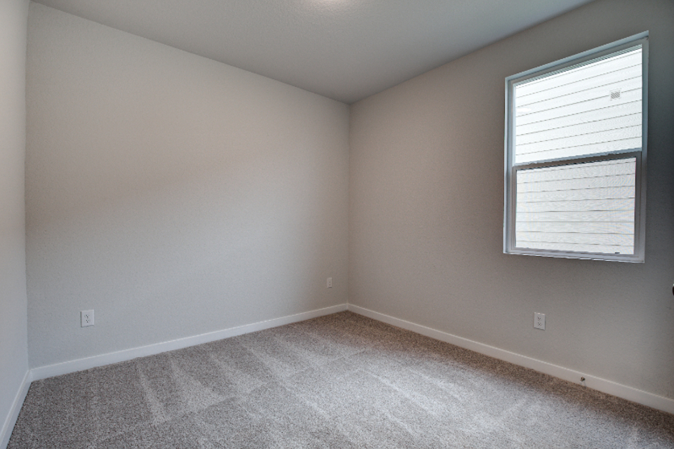 A room with a window and a carpet.