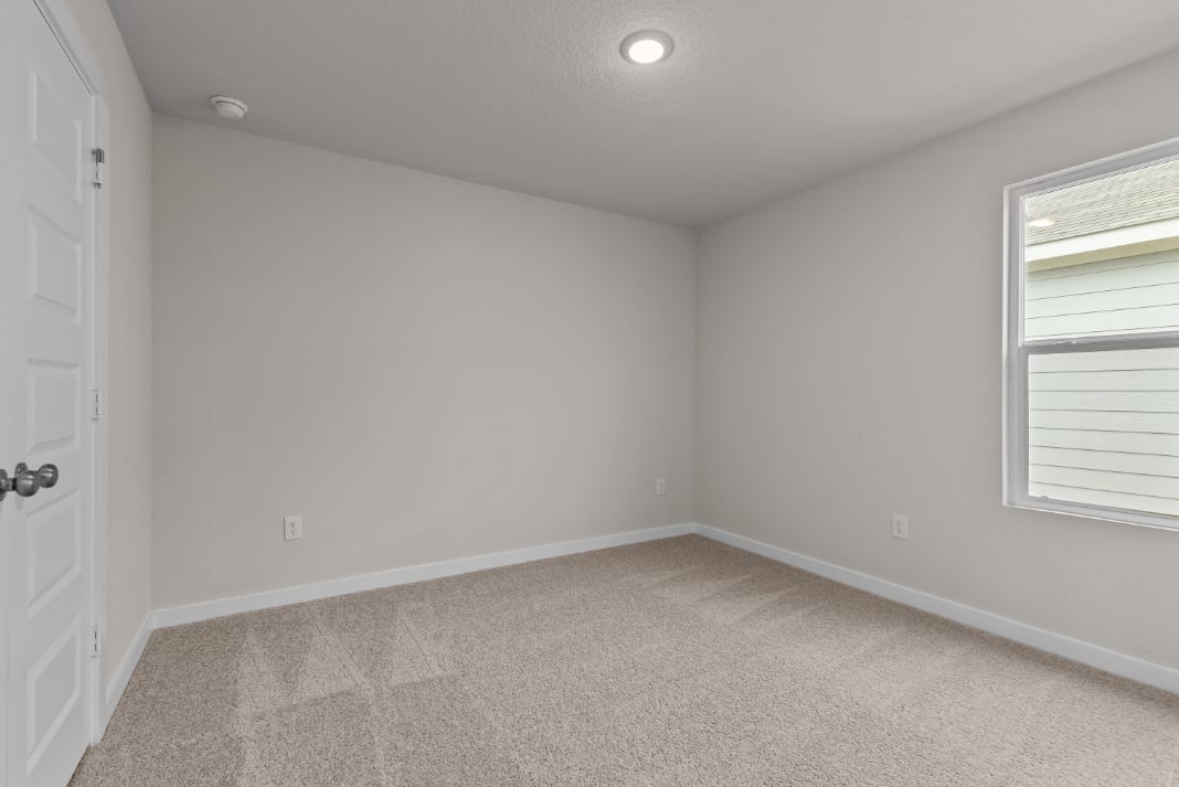 A room with a carpet and a door.