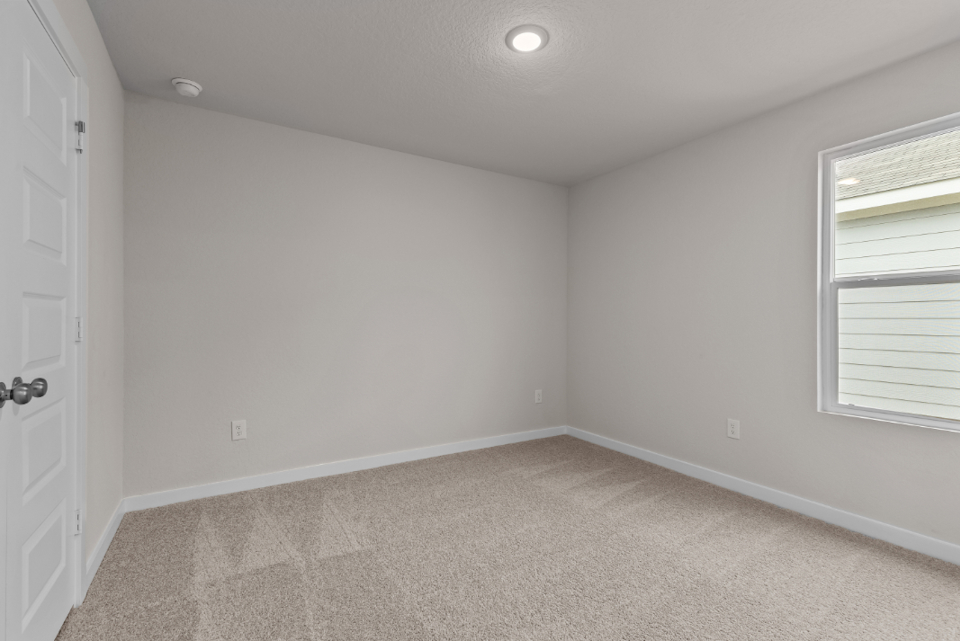 A room with a carpet and a door.