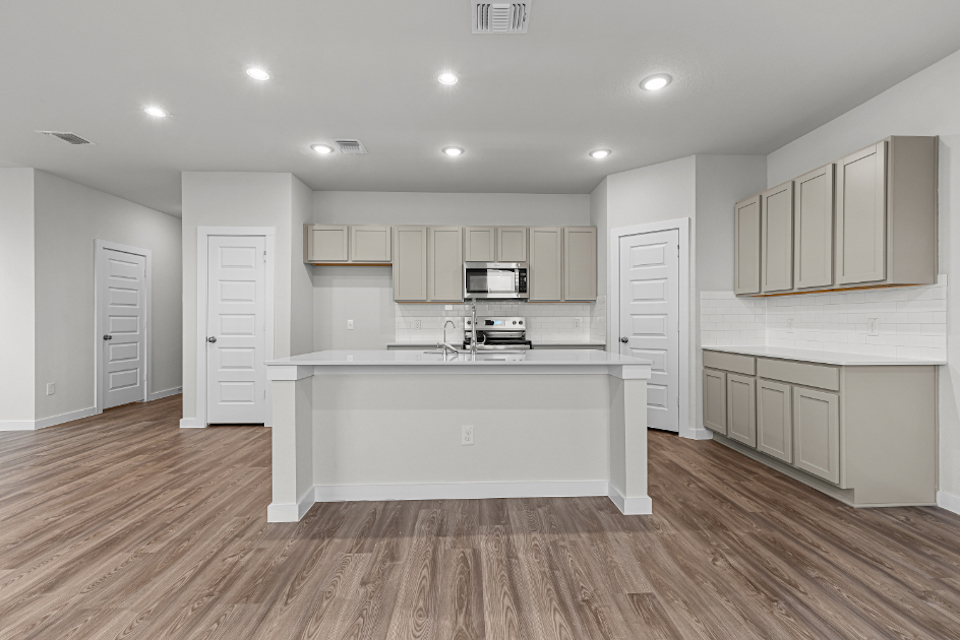 A kitchen with white cabinets.