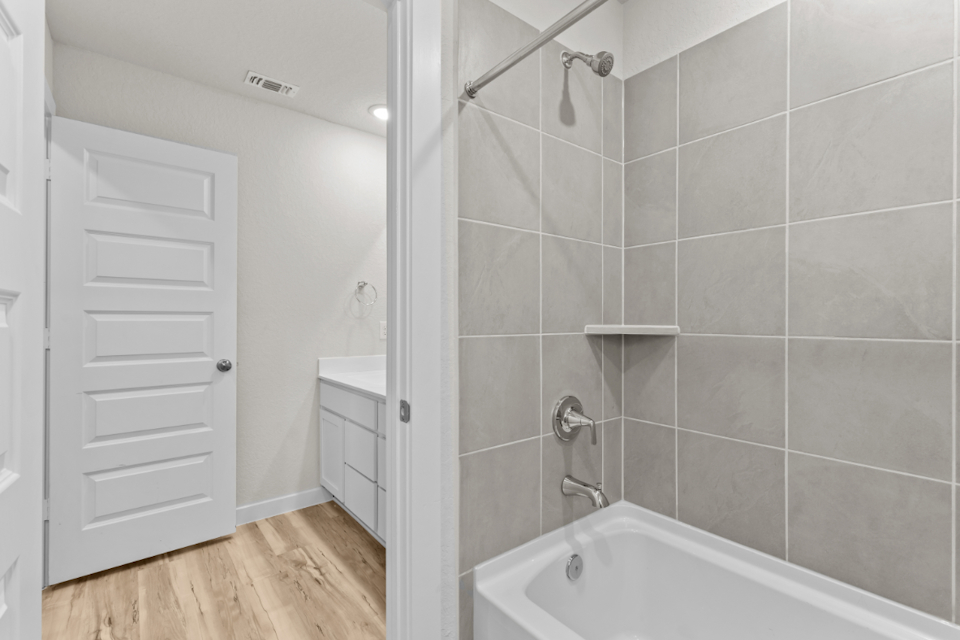A bathroom with a shower and a bathtub.