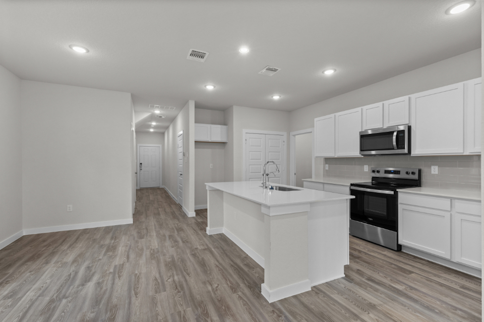 A kitchen with white cabinets.