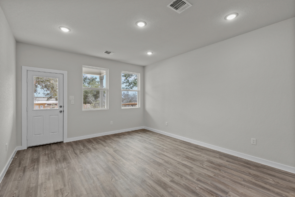A room with a wood floor and white walls.