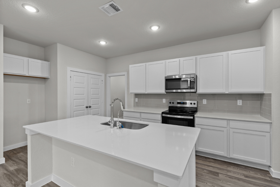 A kitchen with white cabinets.