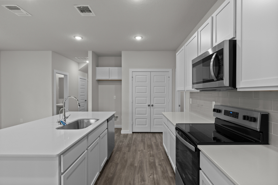 A kitchen with white cabinets.