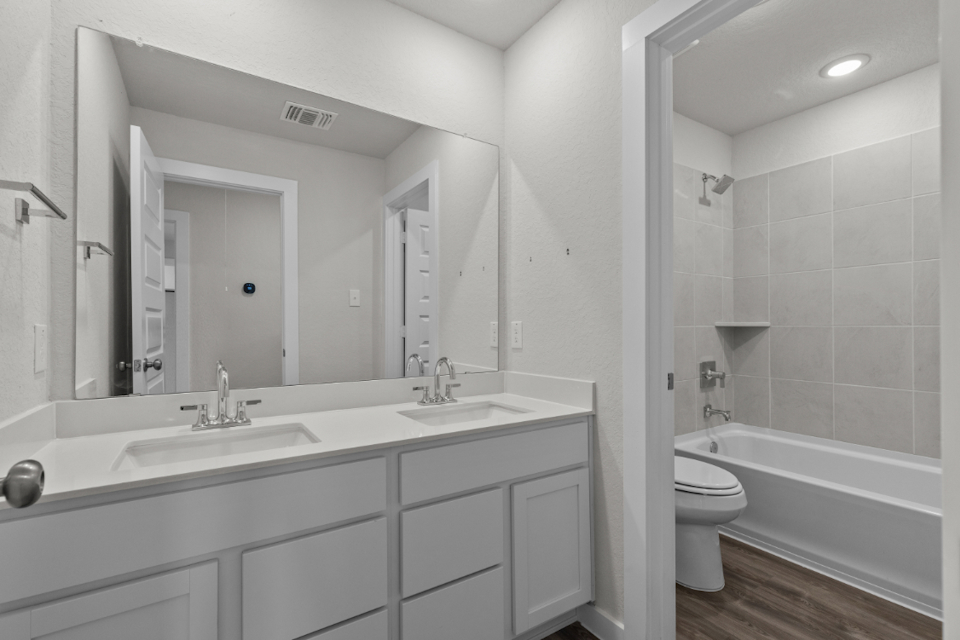 A bathroom with a tub sink and toilet.