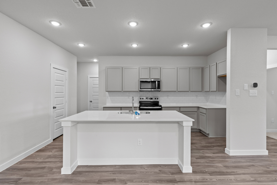 A kitchen with white cabinets.