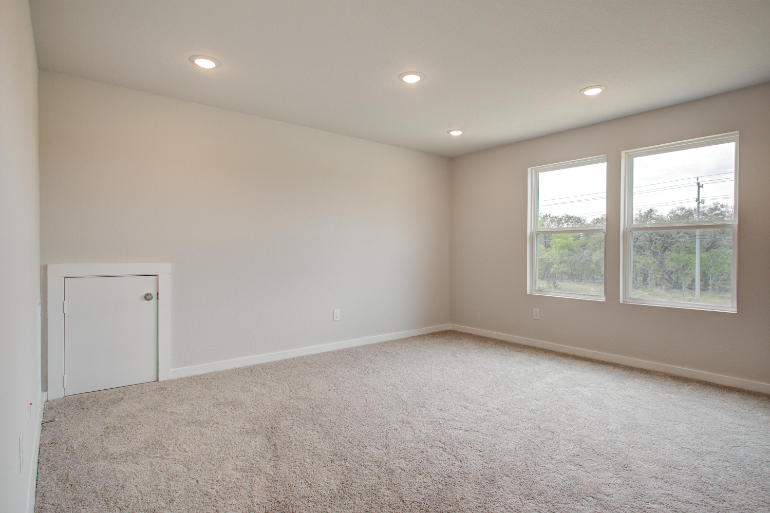 A room with a carpet and windows.