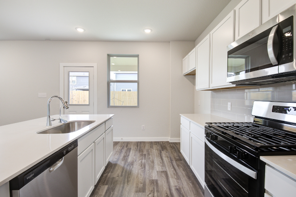 A kitchen with white cabinets.