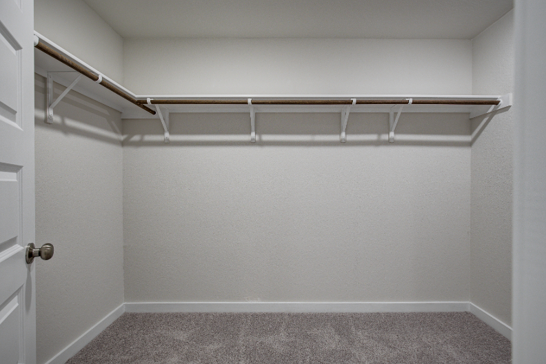 A white wall with a metal bar.