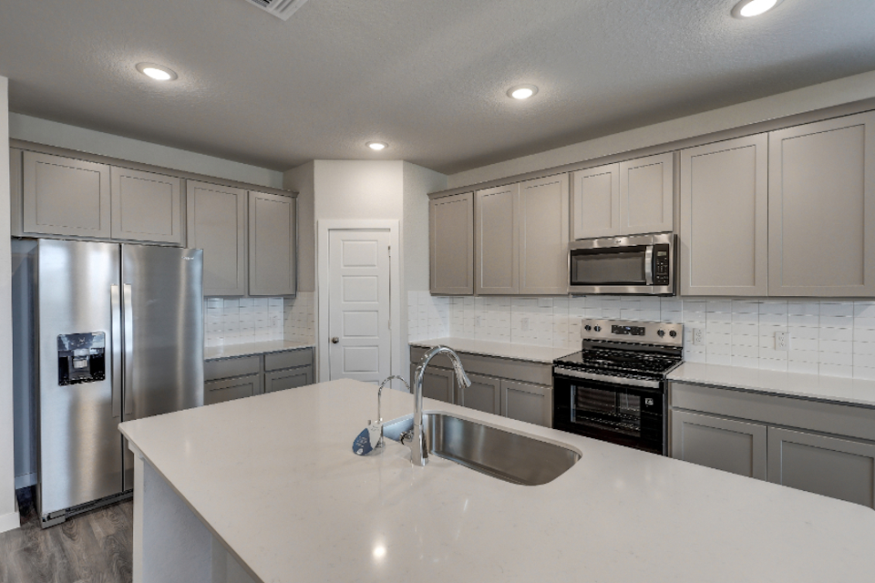 A kitchen with white cabinets.