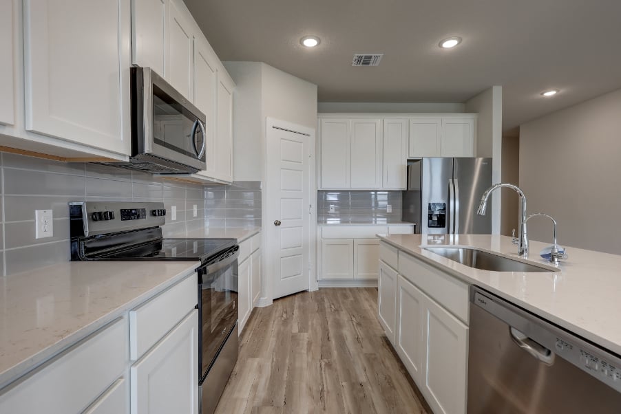 A kitchen with white cabinets.