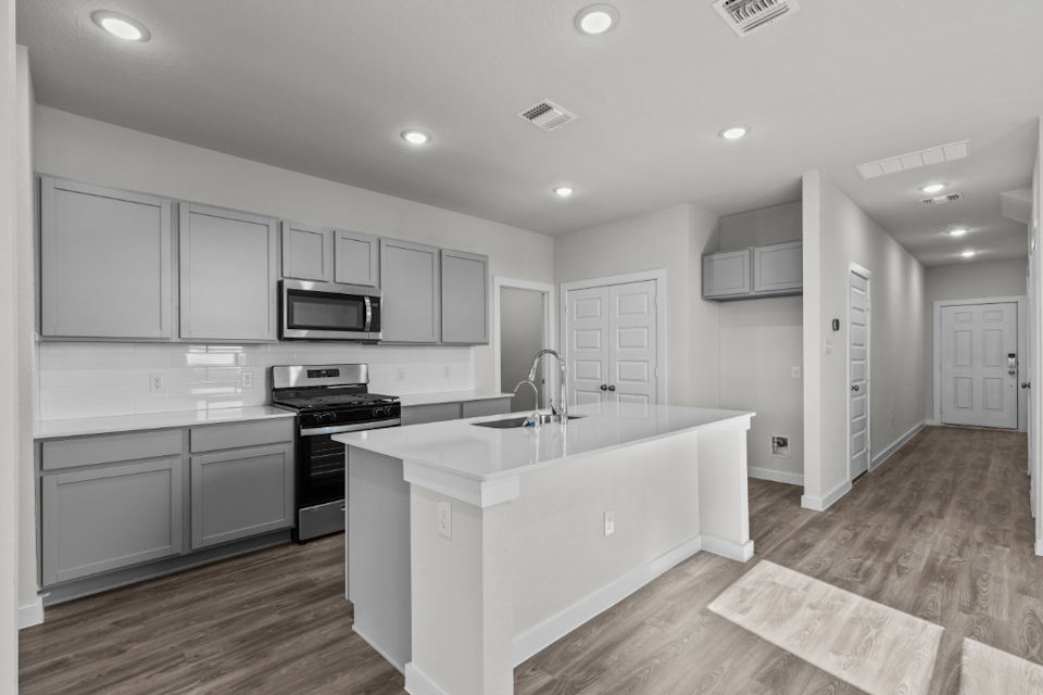 A kitchen with white cabinets.