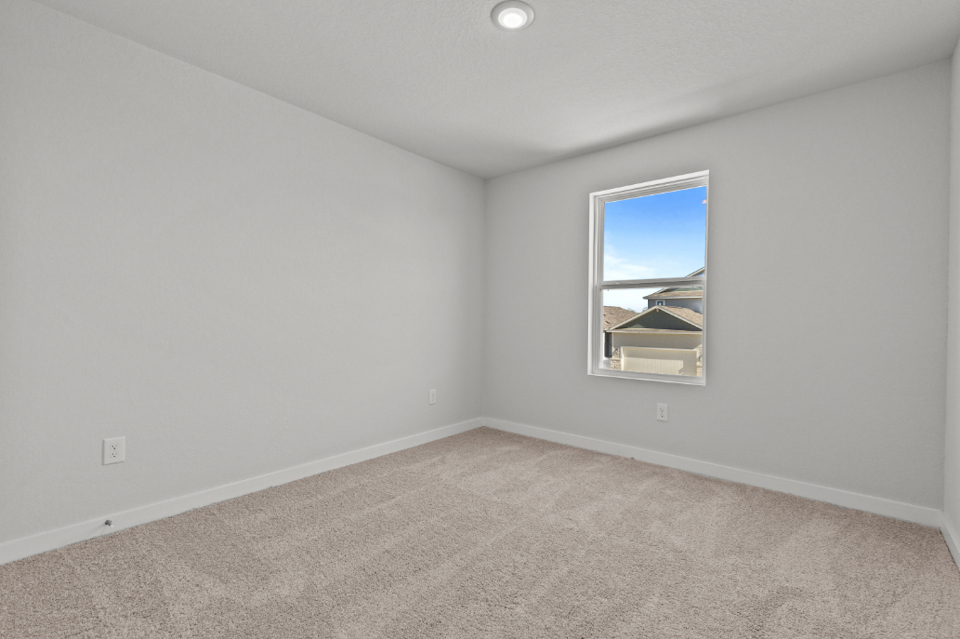 A room with a window and carpet.