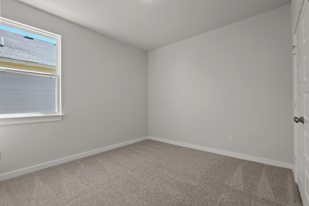 A room with a carpet and a window.