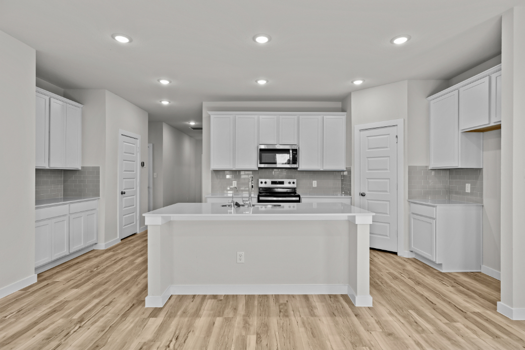A kitchen with white cabinets.