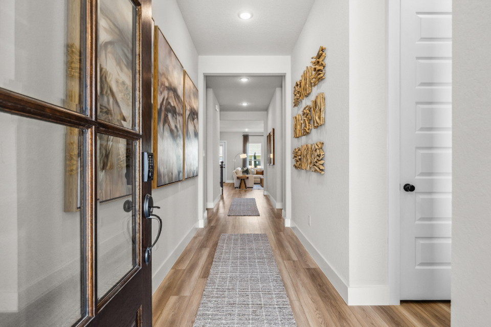 A hallway with a wall of paintings.