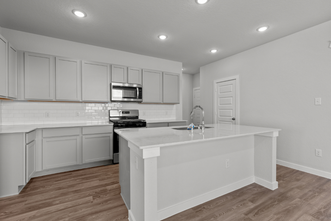 A kitchen with white cabinets.