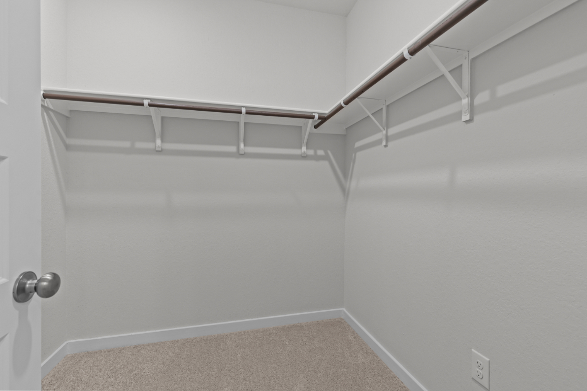 A white wall with a metal bar.