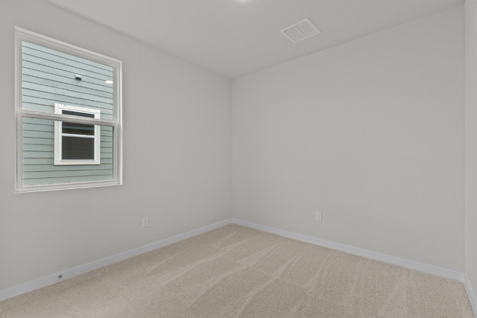 A room with a window and a rug.