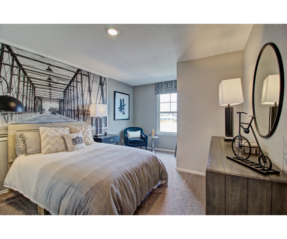 A bedroom with a bed and a mirror.