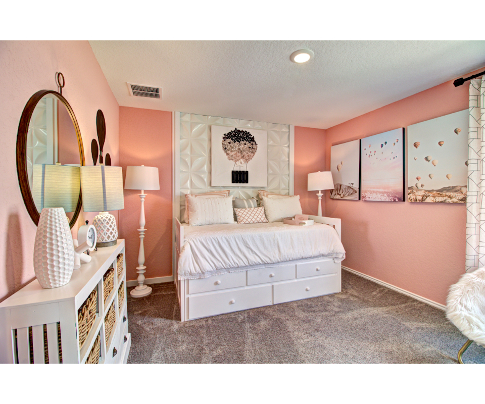 A bedroom with pink walls.