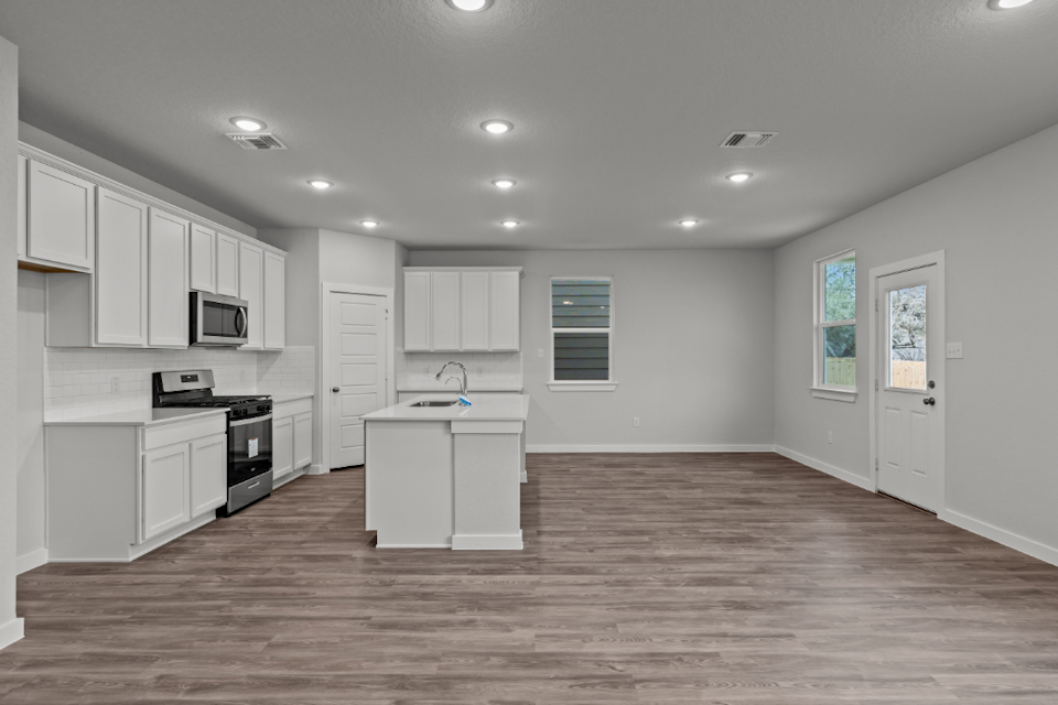 A kitchen with white cabinets.