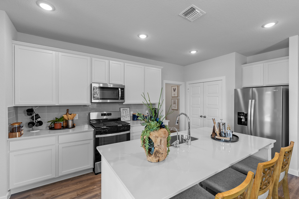 A kitchen with white cabinets.
