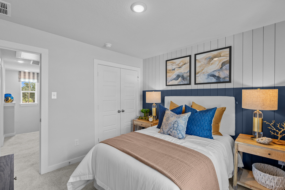 A bedroom with a bed and lamps.