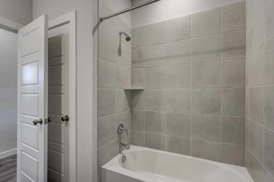 A bathroom with a bathtub and shower.