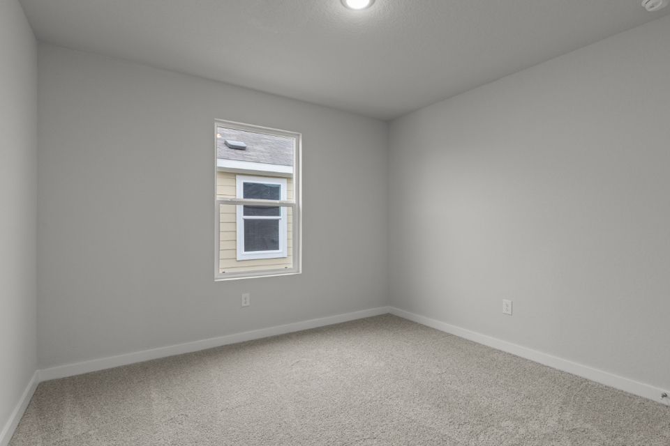 A room with a window and carpet.