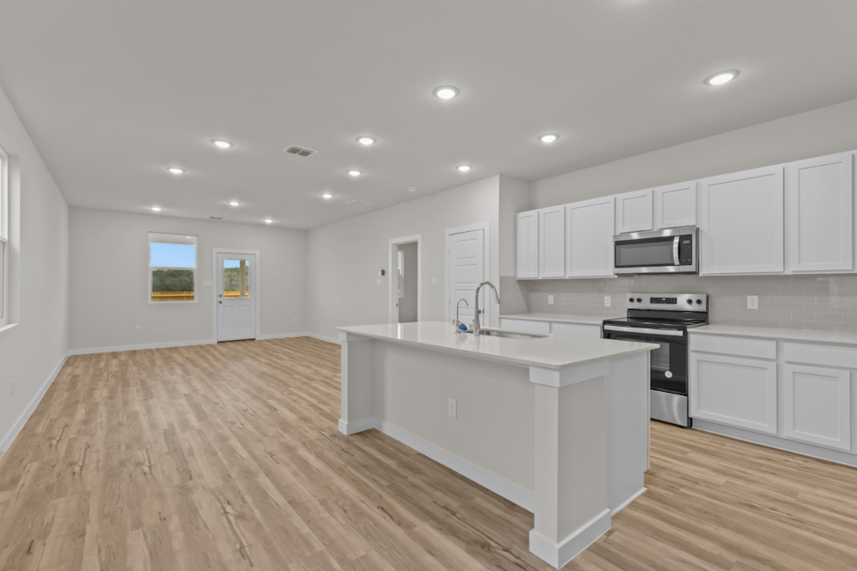 A kitchen with white cabinets.