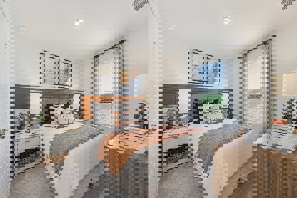 A bedroom with a bed and a table.