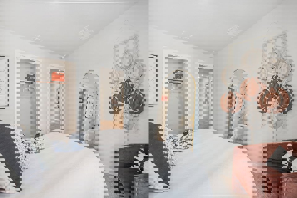 A bedroom with a bed and a mirror.