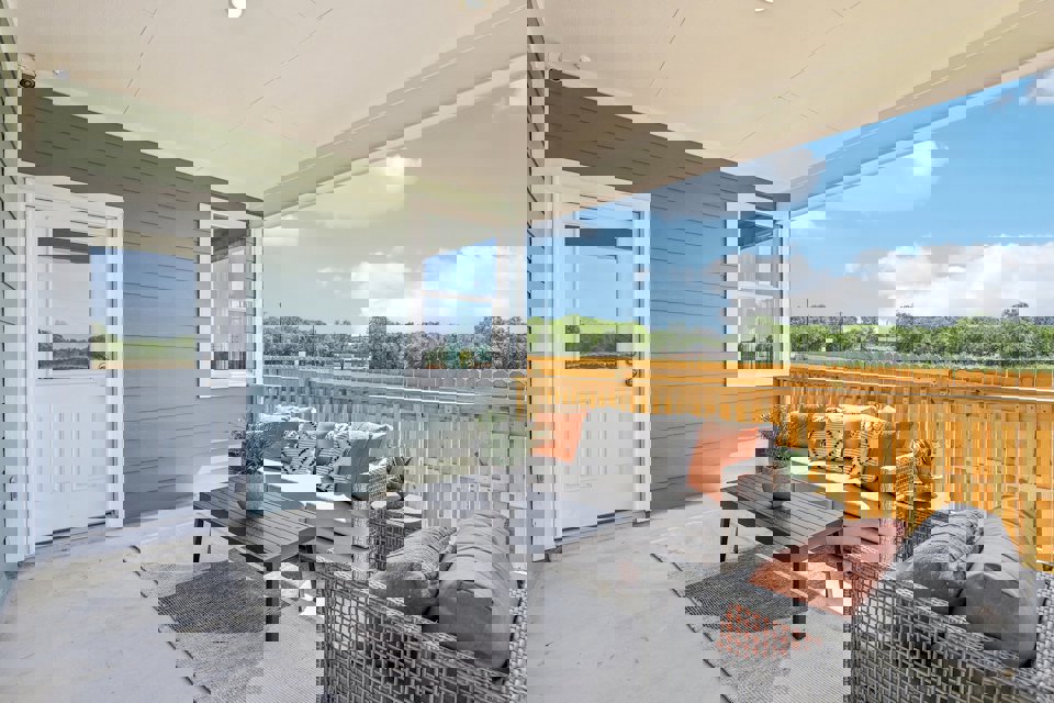 A patio with a couch and a table and a chair in front of it.