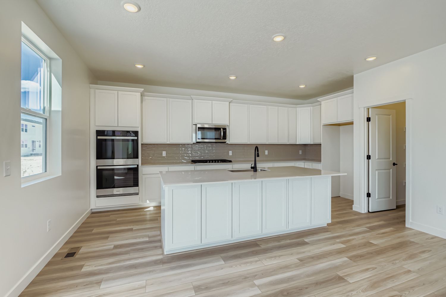A kitchen with white cabinets.
