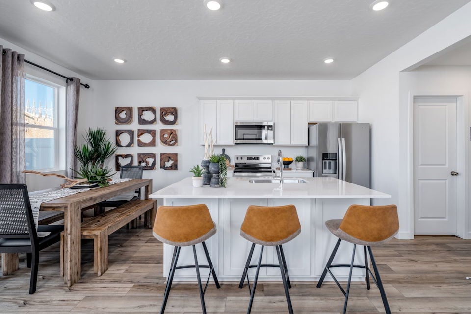 A kitchen with a table and chairs.