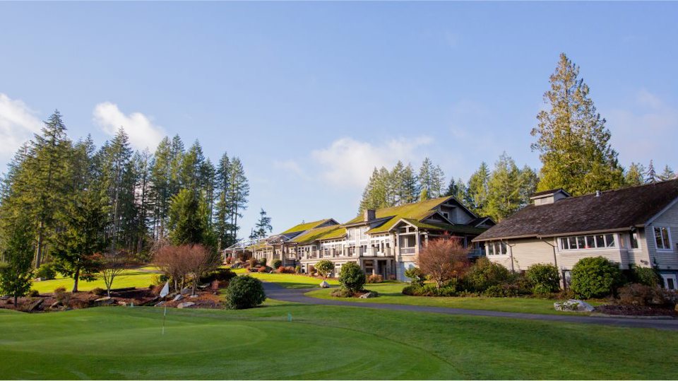 A large house with a lawn and trees in the front.