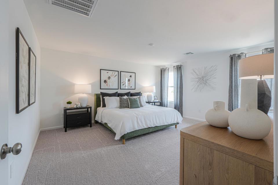 A bedroom with a bed and lamps.