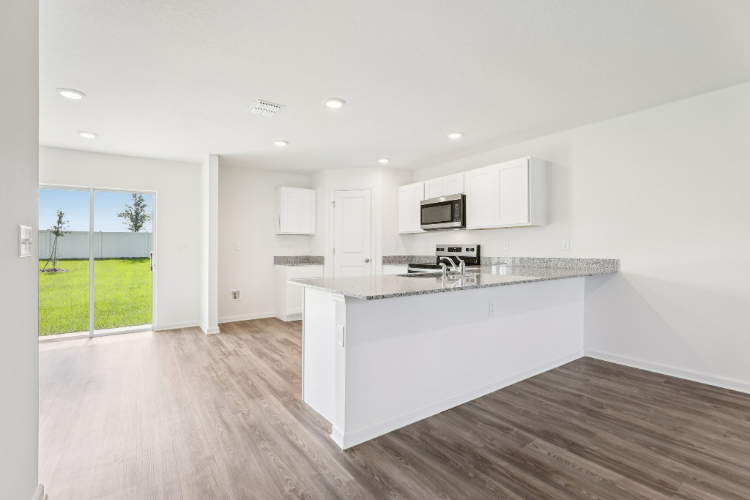 A kitchen with white cabinets.