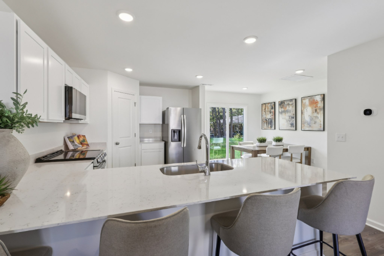 A kitchen with a dining table and chairs.