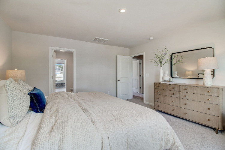 A bedroom with a bed and dresser.