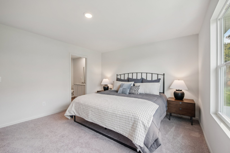 A bedroom with a bed and lamps.